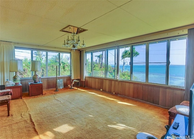 sunroom / solarium with a chandelier and a water view