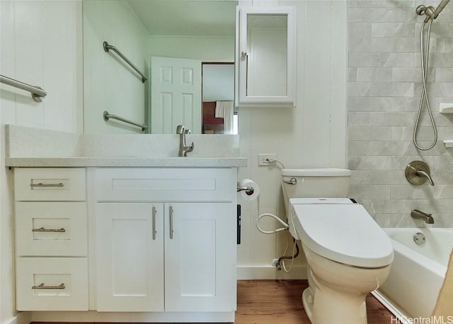 full bathroom with hardwood / wood-style flooring, vanity, toilet, and tiled shower / bath combo