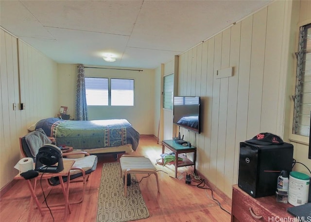 bedroom featuring wood walls and wood-type flooring