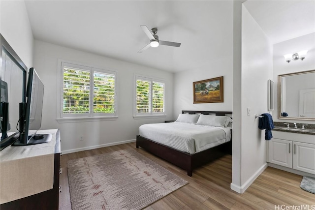 bedroom featuring light hardwood / wood-style floors, ceiling fan, and sink