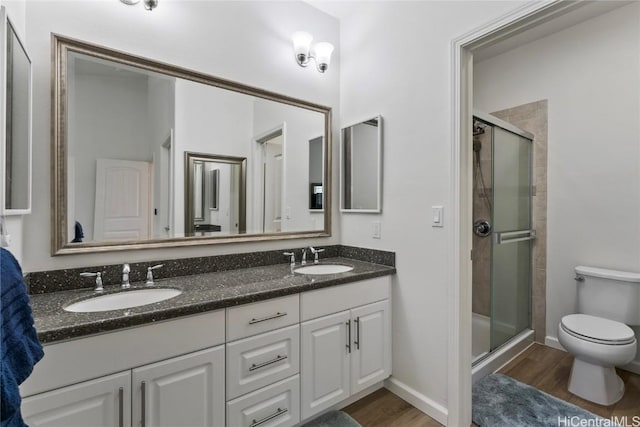 bathroom featuring hardwood / wood-style floors, vanity, and a shower with shower door