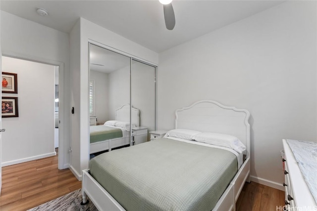 bedroom with hardwood / wood-style floors, ceiling fan, and a closet