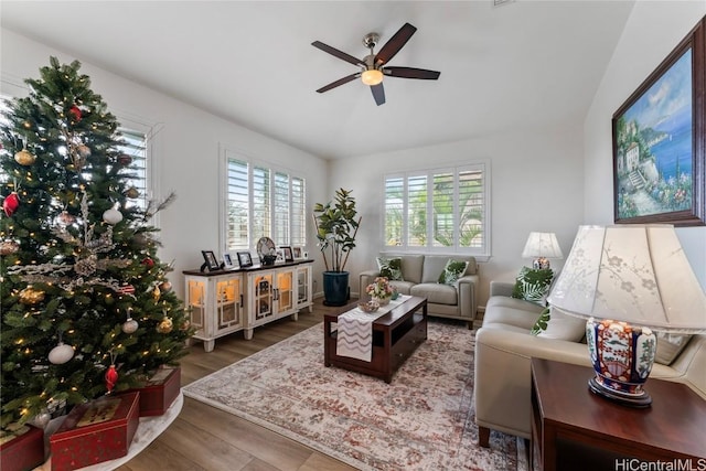 living room with ceiling fan, wood-type flooring, and lofted ceiling