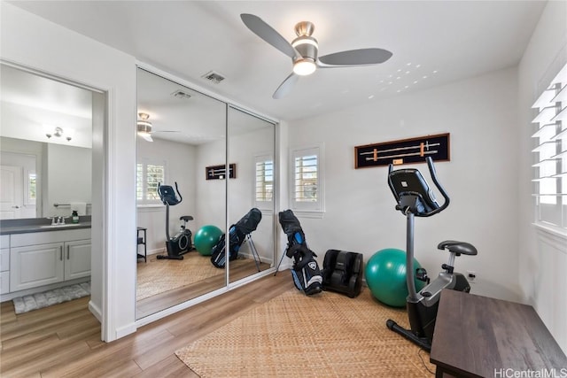 exercise area with light hardwood / wood-style flooring and ceiling fan