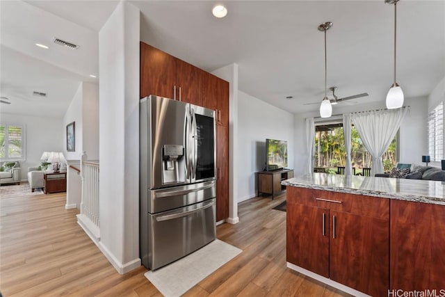 kitchen with stainless steel fridge with ice dispenser, light hardwood / wood-style flooring, ceiling fan, and light stone counters