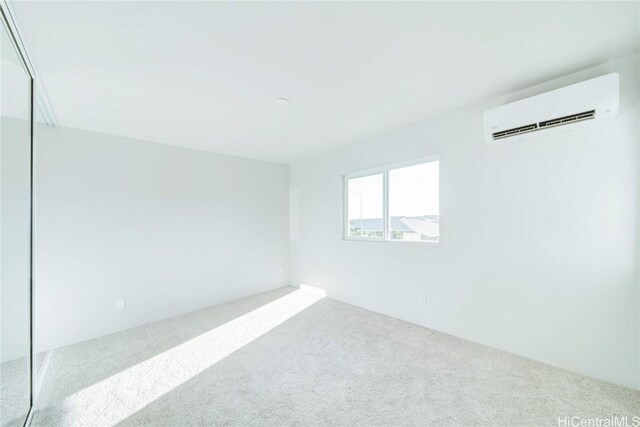 carpeted spare room featuring an AC wall unit