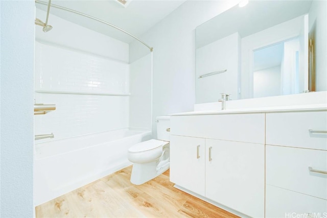 full bathroom featuring washtub / shower combination, vanity, hardwood / wood-style flooring, and toilet