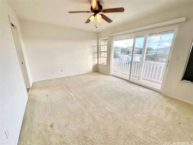 carpeted spare room with ceiling fan