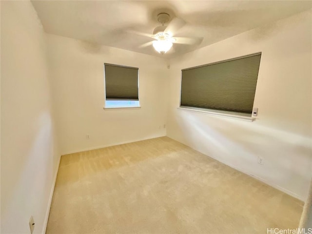 carpeted spare room with ceiling fan