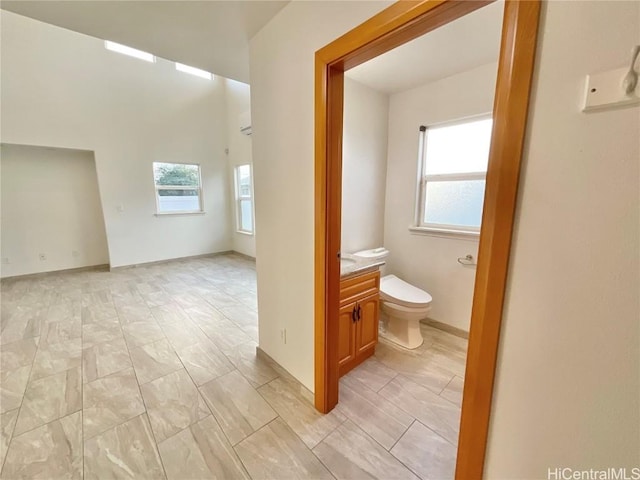 bathroom with vanity, a healthy amount of sunlight, and toilet