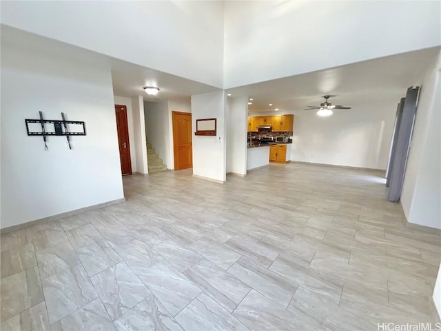 unfurnished living room featuring ceiling fan