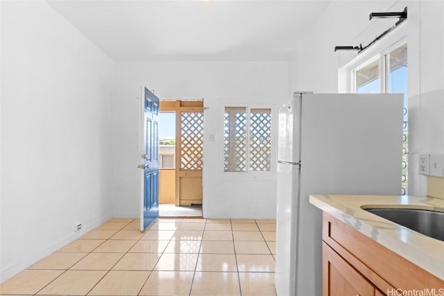 kitchen with white fridge and light tile patterned flooring