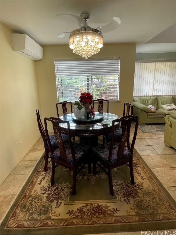 dining space with tile patterned floors, an AC wall unit, and an inviting chandelier