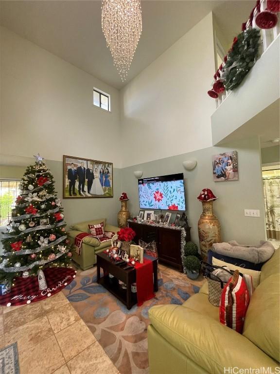 tiled living room featuring a chandelier and a high ceiling