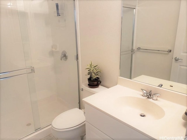 bathroom with vanity, a shower with shower door, and toilet