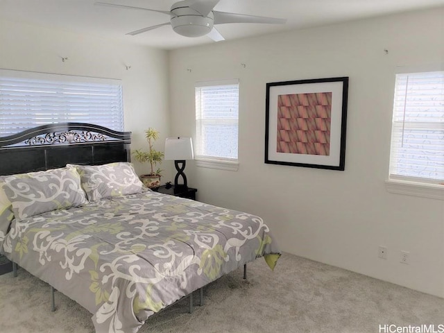 bedroom with light carpet, multiple windows, and ceiling fan