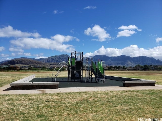 view of jungle gym featuring a mountain view and a yard