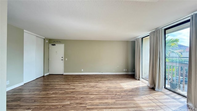 spare room with hardwood / wood-style flooring and a textured ceiling