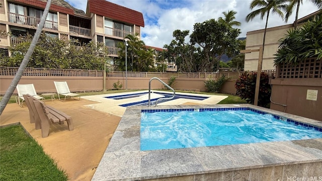 view of swimming pool with a hot tub