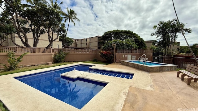 view of swimming pool with an in ground hot tub