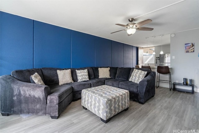 living room featuring rail lighting, light hardwood / wood-style floors, and ceiling fan