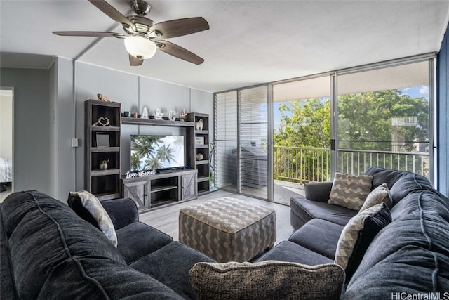 living room with ceiling fan, expansive windows, and light hardwood / wood-style floors