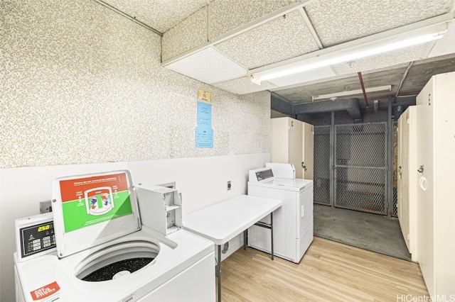 shared laundry area with light wood finished floors and washing machine and clothes dryer