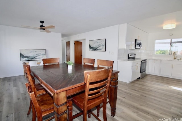 dining space with ceiling fan, sink, and light hardwood / wood-style floors