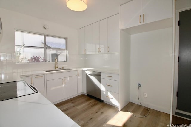 kitchen featuring white cabinets, light wood-type flooring, stainless steel dishwasher, and sink