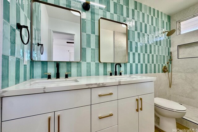 bathroom with vanity, tile walls, and toilet