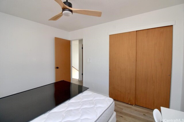 bedroom featuring light wood-type flooring, a closet, and ceiling fan