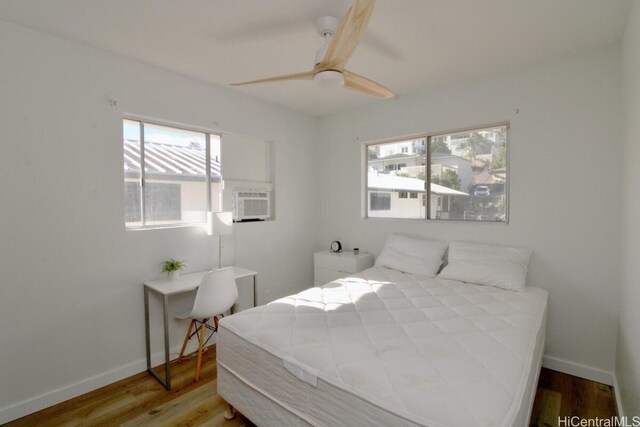 bedroom with wood-type flooring, ceiling fan, and cooling unit