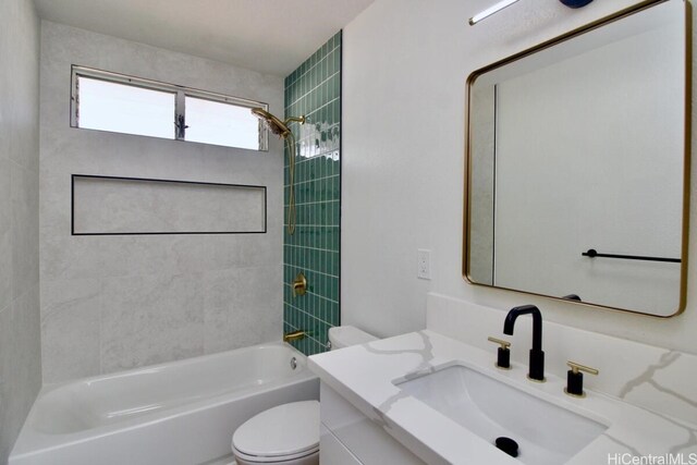 full bathroom featuring vanity, tiled shower / bath combo, and toilet