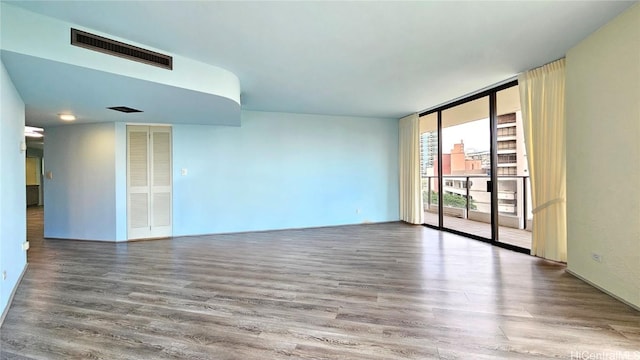 unfurnished room with hardwood / wood-style floors and floor to ceiling windows