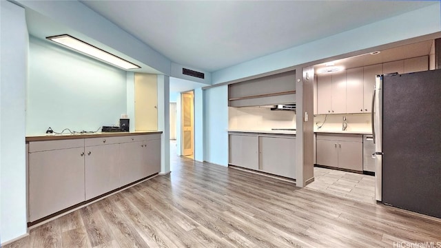 kitchen with stainless steel fridge and light wood-type flooring