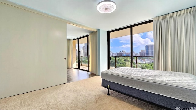 bedroom with carpet, access to exterior, and expansive windows