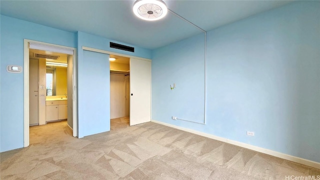 unfurnished bedroom with a closet and light colored carpet