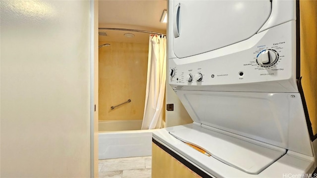 clothes washing area featuring stacked washer and clothes dryer