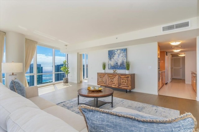 living room featuring light wood-type flooring and a water view