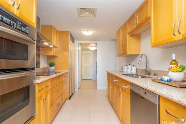 kitchen featuring light stone counters, sink, light tile patterned floors, and appliances with stainless steel finishes