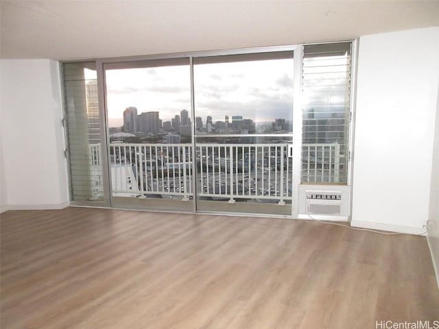 unfurnished room featuring hardwood / wood-style flooring and expansive windows