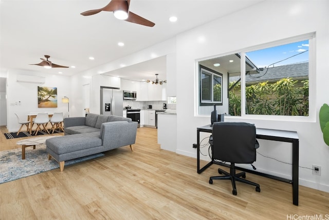 office area with ceiling fan with notable chandelier, light hardwood / wood-style floors, and a wall unit AC