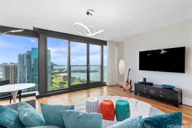 living room with floor to ceiling windows, light hardwood / wood-style flooring, and a chandelier