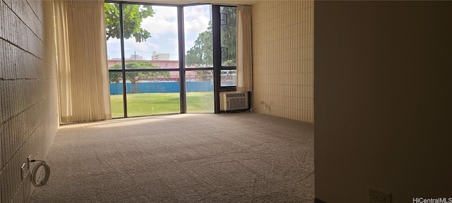 spare room with carpet flooring and an AC wall unit