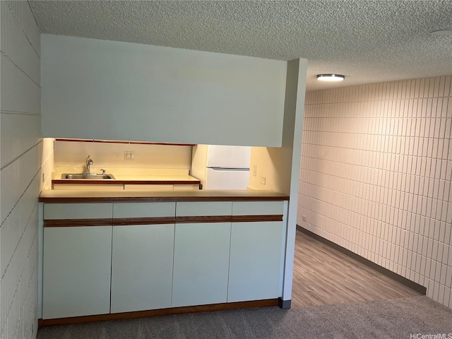 855 Makahiki Way Unit 207, Honolulu, HI 96826 - kitchen with freestanding refrigerator, a sink, a textured ceiling, and carpet