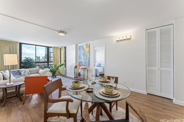 dining space featuring light hardwood / wood-style floors and expansive windows