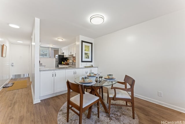 dining room with light hardwood / wood-style flooring and sink