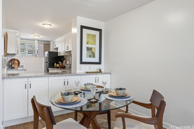 dining space featuring light wood-type flooring and sink