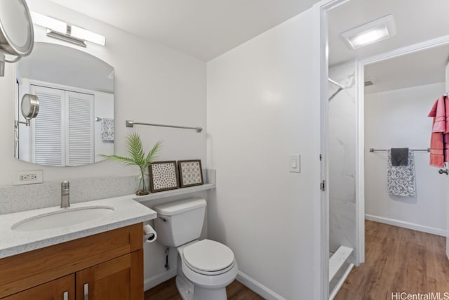 bathroom featuring vanity, hardwood / wood-style flooring, toilet, and walk in shower