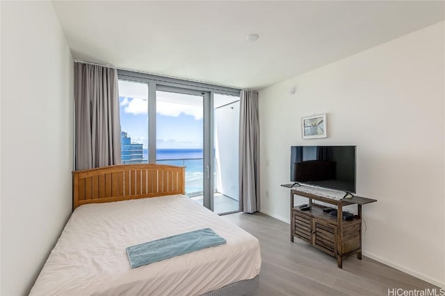 bedroom with wood-type flooring and access to outside